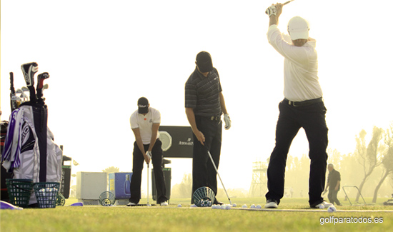 Imagen de tres jugadores de golf profesionales entrenado el swing en el campo de tiro largo