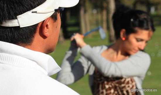 Imagen de un profesor de golf dando clase a una alumna